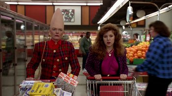 Movie still from “Coneheads” (1993), directed by Steve Barron – Two people in a grocery store with shopping carts; Medium shot, Low angle