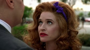 Movie still from “Coneheads” (1993), directed by Steve Barron – A person wearing a headband; Close Up shot, Over the shoulder angle