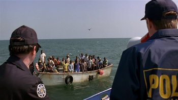 Movie still from “Coneheads” (1993), directed by Steve Barron – A group of people on a boat in the water; Extreme Wide shot, High angle