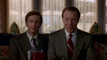 Movie still from “Coneheads” (1993), directed by Steve Barron – A couple of men wearing suits and ties; Close Up shot, Low angle