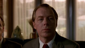 Movie still from “Coneheads” (1993), directed by Steve Barron – A person wearing a suit and tie; Close Up shot, Low angle