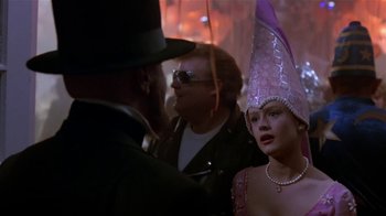 Movie still from “Coneheads” (1993), directed by Steve Barron – A man and woman wearing a hat and a man in a suit; Close Up shot, Over the shoulder angle