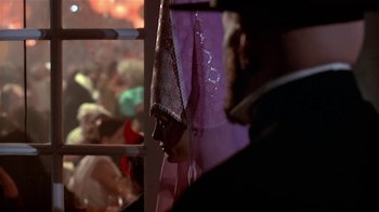 Movie still from “Coneheads” (1993), directed by Steve Barron – A man in a purple shirt is looking out of a window; Close Up shot, Over the shoulder angle