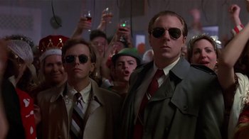 Movie still from “Coneheads” (1993), directed by Steve Barron – A group of men standing next to each other in front of a crowd; Medium shot, Low angle