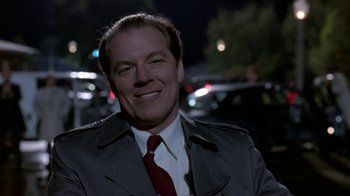 Movie still from “Coneheads” (1993), directed by Steve Barron – A man that is wearing a suit and tie; Close Up shot, Low angle