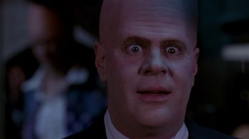 Movie still from “Coneheads” (1993), directed by Steve Barron – A man with bald head looking surprised at the camera; Close Up shot, Low angle