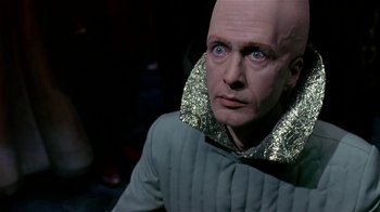 Movie still from “Coneheads” (1993), directed by Steve Barron – A man with a bald head wearing a green jacket; Close Up shot, Low angle