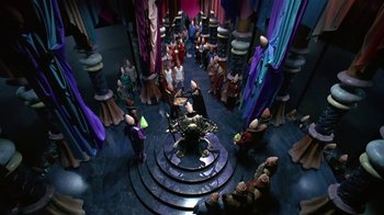 Movie still from “Coneheads” (1993), directed by Steve Barron – An overhead view of a group of people gathered in a room; Extreme Wide shot, High angle