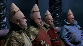 Movie still from “Coneheads” (1993), directed by Steve Barron – A group of people dressed in costumes for a costume party; Medium shot, Low angle