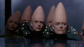 Movie still from “Coneheads” (1993), directed by Steve Barron – A group of people with odd hats on their heads; Close Up shot, High angle