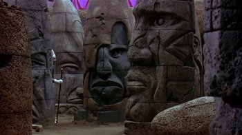 Movie still from “Coneheads” (1993), directed by Steve Barron – Many statues in the middle of the room; Wide shot, Low angle