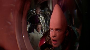 Movie still from “Coneheads” (1993), directed by Steve Barron – A man with a strange hat in front of a mirror; Close Up shot, High angle