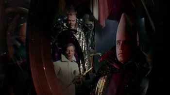 Movie still from “Coneheads” (1993), directed by Steve Barron – A group of people dressed in costumes in front of a mirror; Medium shot, Over the shoulder angle