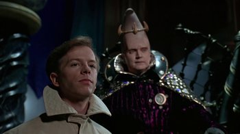 Movie still from “Coneheads” (1993), directed by Steve Barron – A man and a woman dressed in costumes; Medium shot, Over the shoulder angle