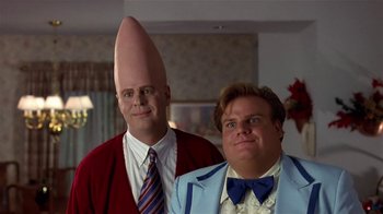 Movie still from “Coneheads” (1993), directed by Steve Barron – Two men in suits and ties are posing for a picture; Close Up shot, Low angle