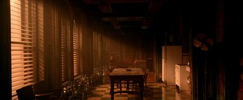 Movie still from “Constantine” (2005), directed by Francis Lawrence – An empty room with a table and chairs and a refrigerator; Extreme Wide shot, High angle