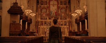Movie still from “Constantine” (2005), directed by Francis Lawrence – A woman standing in front of an ornate church alter; Wide shot, Low angle
