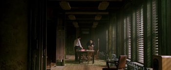 Movie still from “Constantine” (2005), directed by Francis Lawrence – Two men standing at a table in a room; Wide shot, High angle
