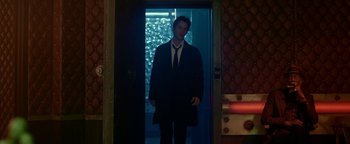 Movie still from “Constantine” (2005), directed by Francis Lawrence – A man standing in front of an open door; Wide shot, Low angle
