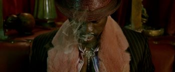 Movie still from “Constantine” (2005), directed by Francis Lawrence – A man in a hat and a fur coat smoking a cigarette; Close Up shot, Overhead angle