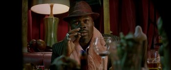 Movie still from “Constantine” (2005), directed by Francis Lawrence – A man sitting at a table with a cigarette in his mouth; Close Up shot, Low angle