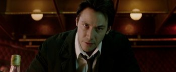 Movie still from “Constantine” (2005), directed by Francis Lawrence – A man in a suit and tie looking at the camera; Close Up shot, Low angle