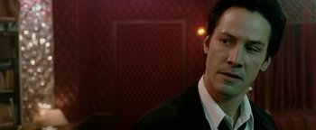 Movie still from “Constantine” (2005), directed by Francis Lawrence – A person wearing a suit and tie; Close Up shot, Over the shoulder angle