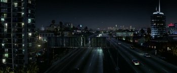Movie still from “Constantine” (2005), directed by Francis Lawrence – A night time view of a freeway and a city skyline; Extreme Wide shot, High angle