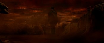 Movie still from “Constantine” (2005), directed by Francis Lawrence – A man in a black suit standing in front of a dark background; Extreme Wide shot, High angle
