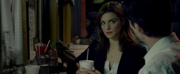 Movie still from “Constantine” (2005), directed by Francis Lawrence – A woman sitting at a table holding a drink; Close Up shot, Over the shoulder angle