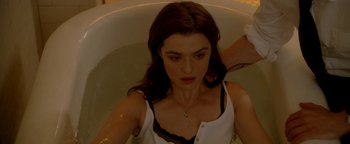 Movie still from “Constantine” (2005), directed by Francis Lawrence – A woman sitting in a bath tub in a room; Close Up shot, Overhead angle