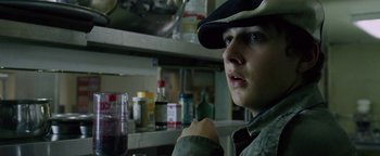 Movie still from “Constantine” (2005), directed by Francis Lawrence – A man in a hat is sitting at a table; Close Up shot, High angle