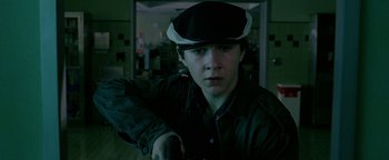 Movie still from “Constantine” (2005), directed by Francis Lawrence – A young man in a hat is holding a gun; Close Up shot, Low angle