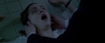 Movie still from “Constantine” (2005), directed by Francis Lawrence – A woman laying on the ground with her hands on her head; Close Up shot, Overhead angle