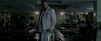 Movie still from “Constantine” (2005), directed by Francis Lawrence – A man in a white suit stands in a room that is flooded with water; Medium shot, Low angle