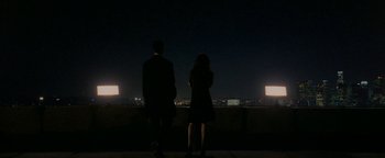 Movie still from “Constantine” (2005), directed by Francis Lawrence – A man and a woman standing on a ledge at night; Extreme Wide shot, High angle