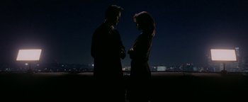 Movie still from “Constantine” (2005), directed by Francis Lawrence – A man and a woman standing next to each other in the dark; Medium shot, Overhead angle