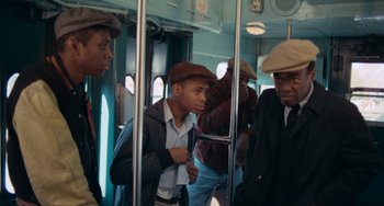 Movie still from “Cooley High” (1975), directed by Michael Schultz – A group of men riding on a train; Medium shot, Over the shoulder angle