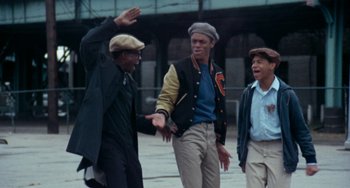 Movie still from “Cooley High” (1975), directed by Michael Schultz – A group of young men standing next to each other on a street; Medium shot, Low angle