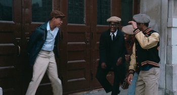 Movie still from “Cooley High” (1975), directed by Michael Schultz – A group of men standing next to each other on a sidewalk; Wide shot, Low angle