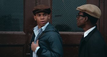 Movie still from “Cooley High” (1975), directed by Michael Schultz – A man wearing a hat and a jacket standing next to another man; Close Up shot, Over the shoulder angle