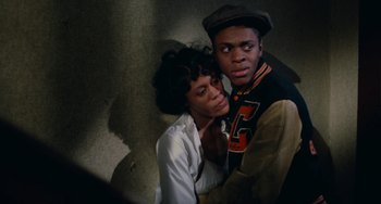 Movie still from “Cooley High” (1975), directed by Michael Schultz – A man and a woman are posing for a picture; Medium shot, High angle