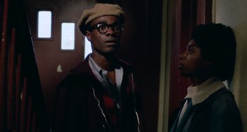Movie still from “Cooley High” (1975), directed by Michael Schultz – A man wearing a hat and glasses standing next to another man; Close Up shot, Low angle