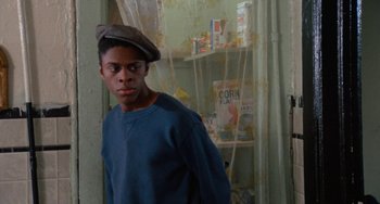 Movie still from “Cooley High” (1975), directed by Michael Schultz – A young man wearing a hat standing in front of a window; Close Up shot, Low angle