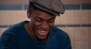 Movie still from “Cooley High” (1975), directed by Michael Schultz – A young man wearing a hat and a blue t - shirt; Close Up shot, Overhead angle