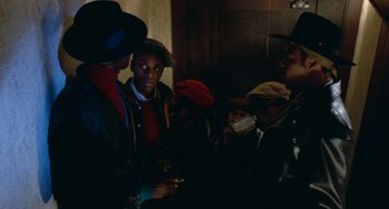 Movie still from “Cooley High” (1975), directed by Michael Schultz – A group of men standing around each other in a room; Medium shot, Over the shoulder angle