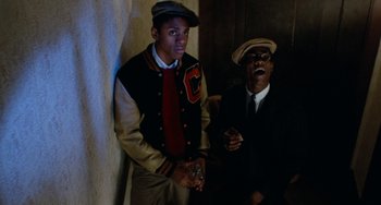 Movie still from “Cooley High” (1975), directed by Michael Schultz – A man and a boy standing next to each other holding game controllers; Medium shot, Low angle