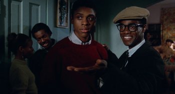 Movie still from “Cooley High” (1975), directed by Michael Schultz – A group of young men standing next to each other in a room; Medium shot, Over the shoulder angle