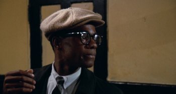 Movie still from “Cooley High” (1975), directed by Michael Schultz – A man wearing a hat , glasses and a suit; Close Up shot, Low angle