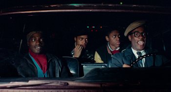 Movie still from “Cooley High” (1975), directed by Michael Schultz – A group of people sitting in a car at night; Medium shot, High angle